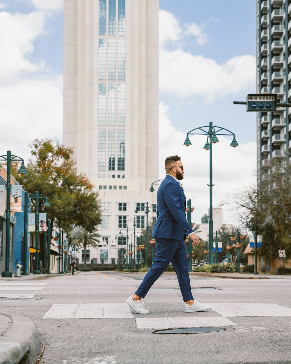 a man in a blue suit crossing the street
