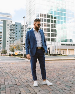 a man wearing a blue suit and white shoes