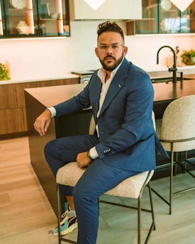 a man in a blue suit sitting on a chair