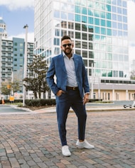 a man in a blue suit standing on a brick road