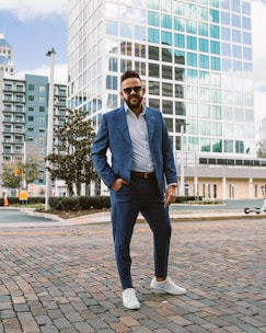 a man in a blue suit standing on a brick road