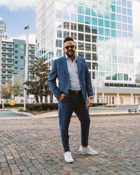 a man in a blue suit standing on a brick road