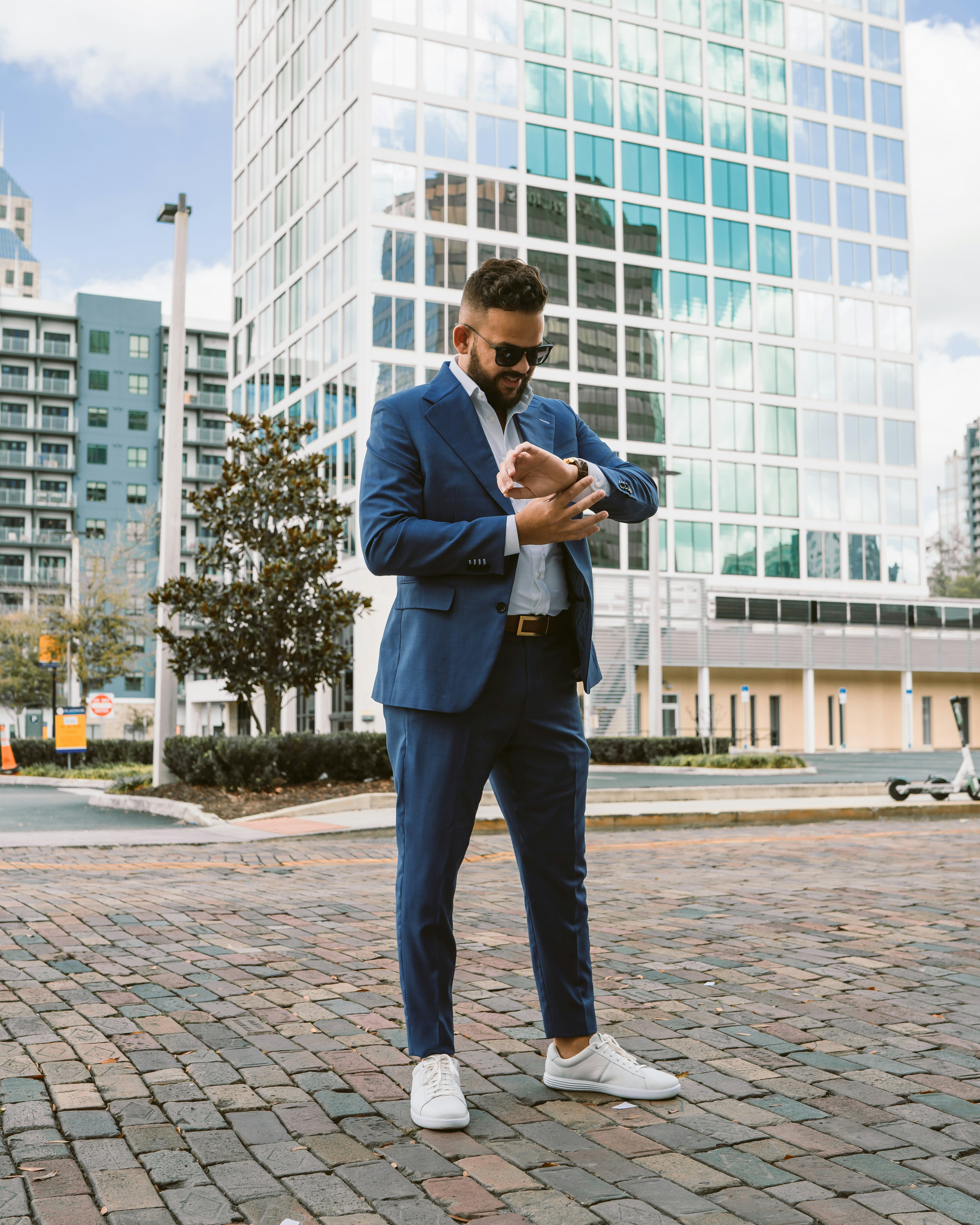a man in a blue suit is looking at his cell phone