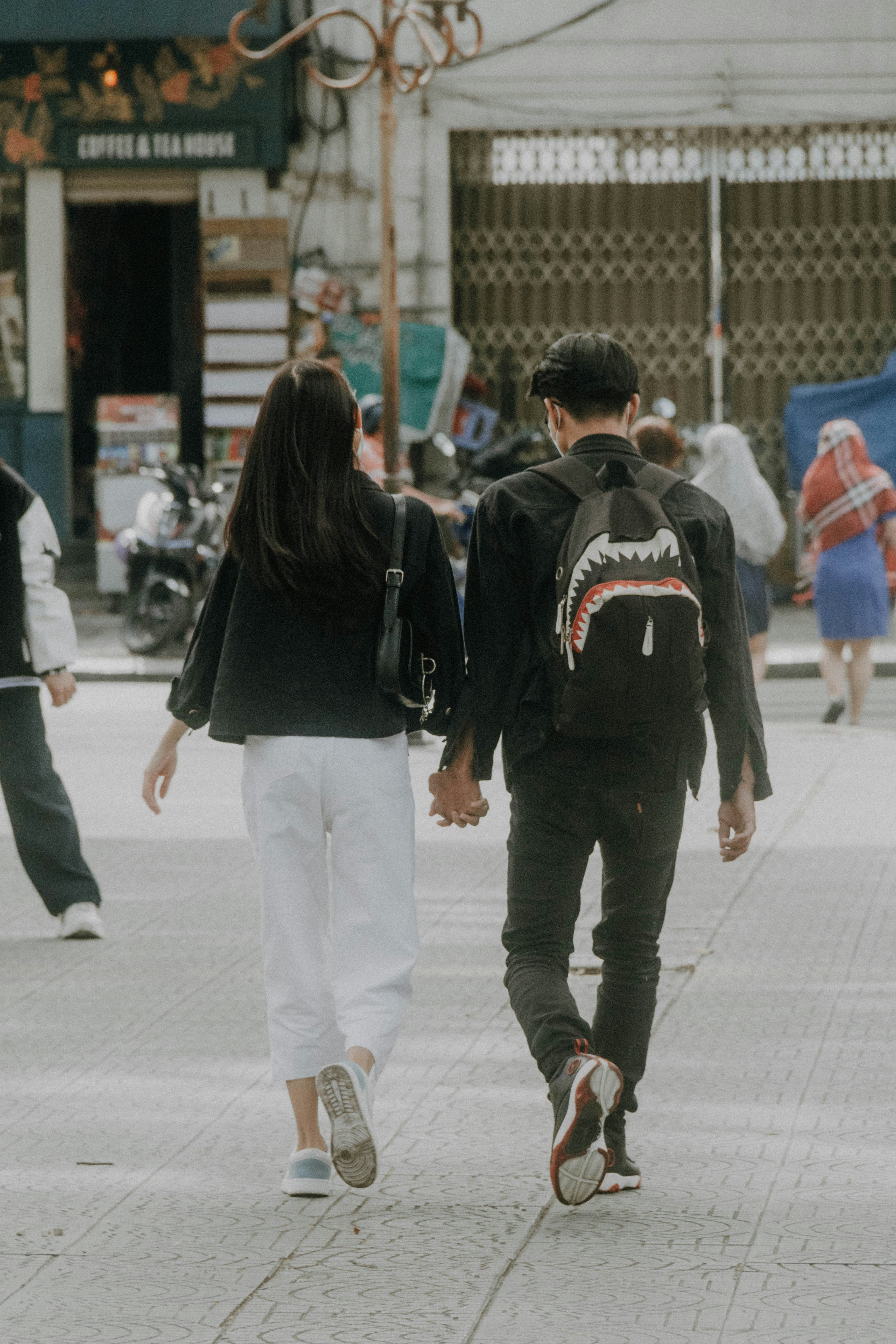 a man and a woman walking down a sidewalk