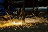 welders working on a piece of metal with sparks