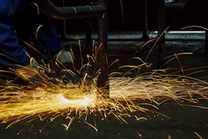 welders working on a piece of metal with sparks