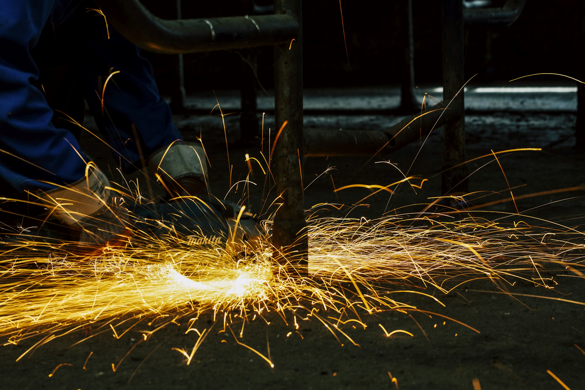 welders working on a piece of metal with sparks