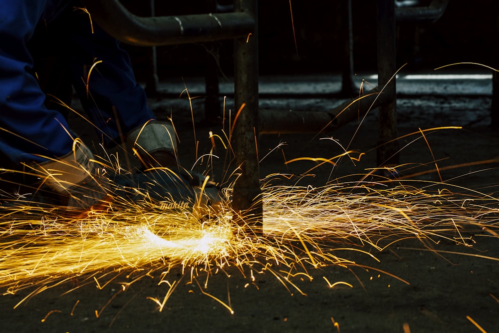 welders working on a piece of metal with sparks