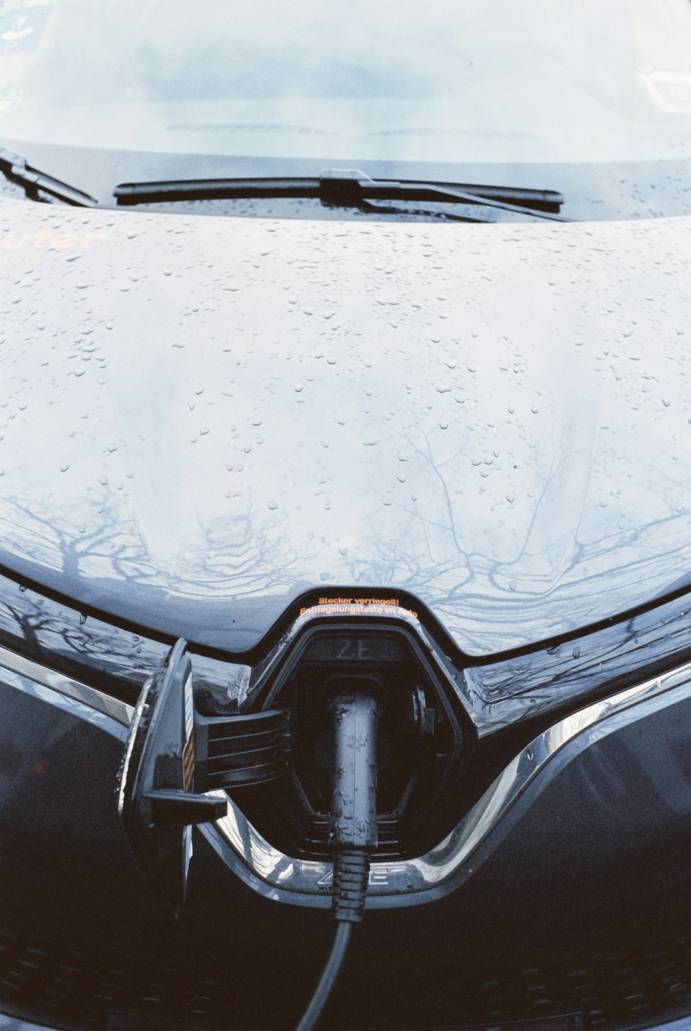 a close up of a car's hood with water droplets on it