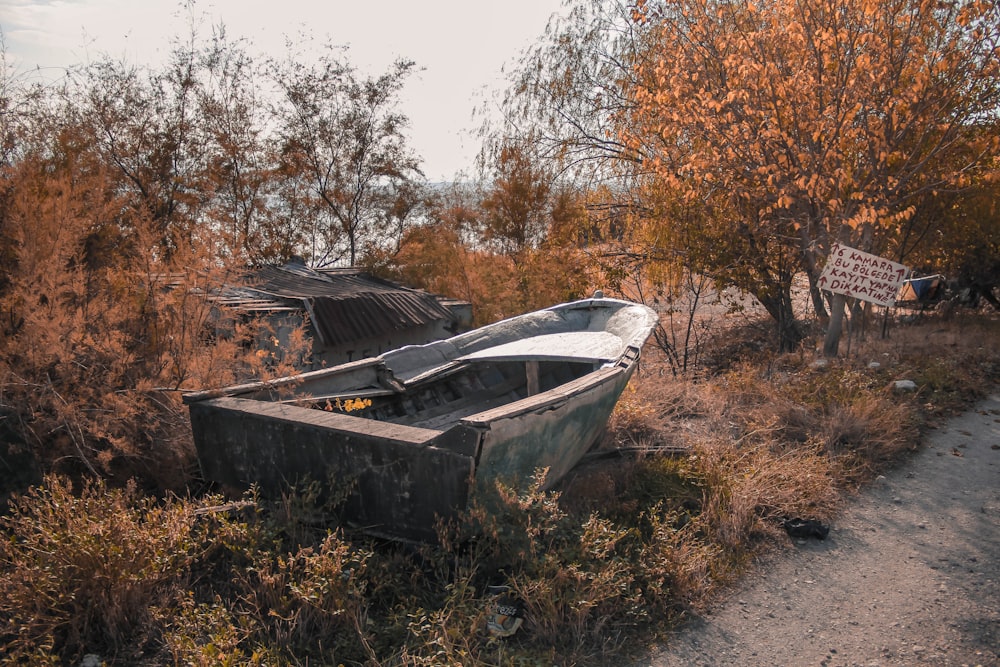 a boat sitting on top of a dry grass field