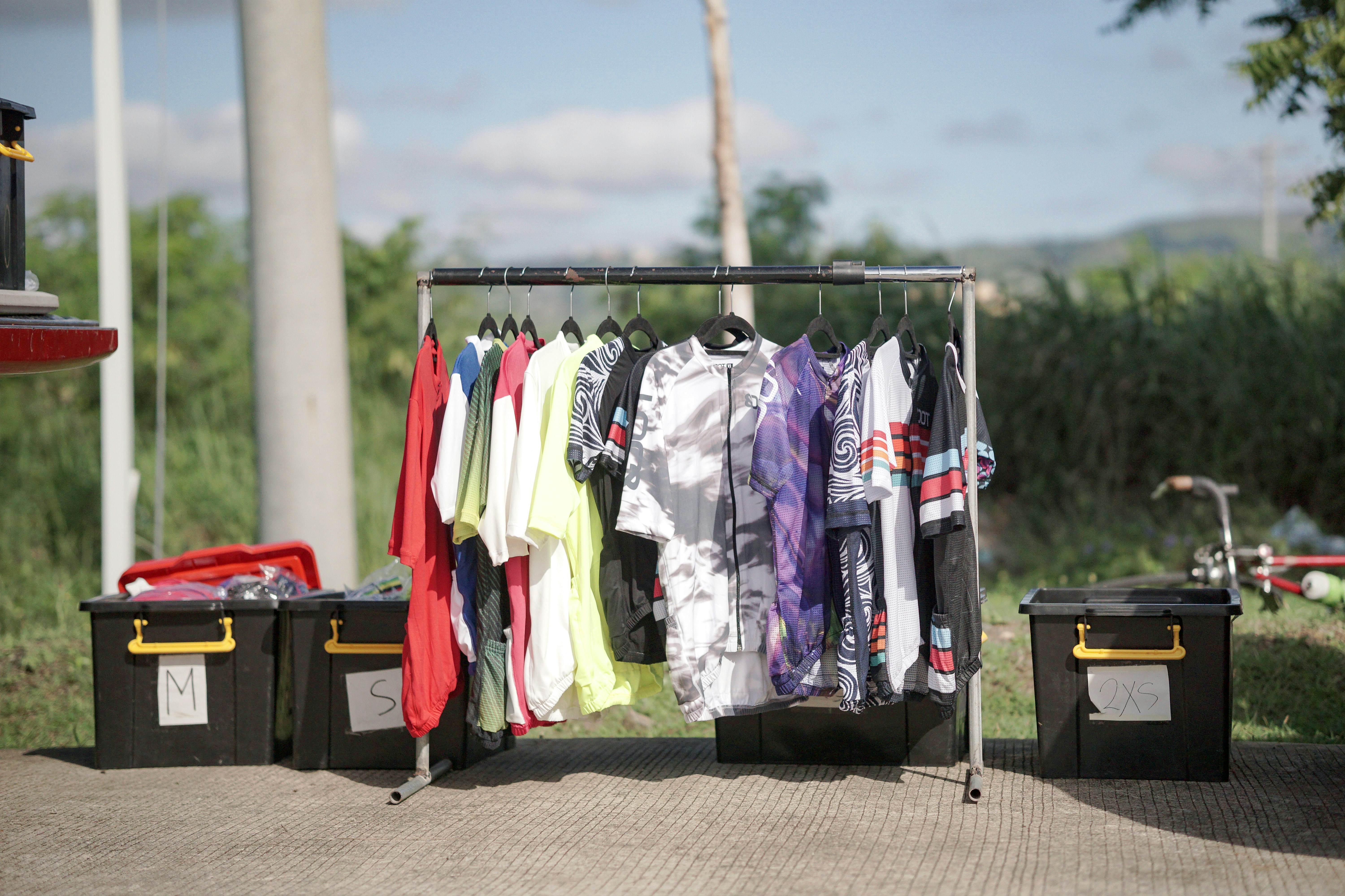 a rack of shirts sitting on top of a sidewalk