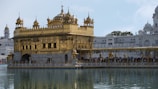 a large golden building sitting next to a body of water