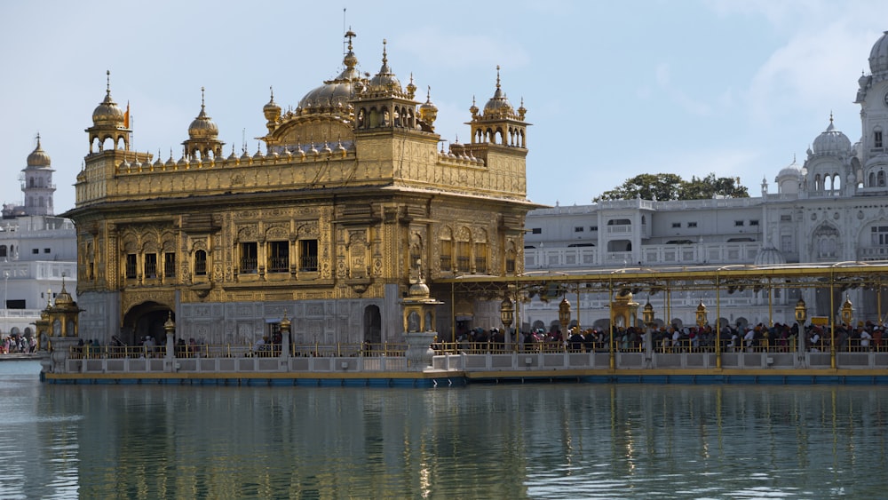 Un gran edificio dorado sentado junto a un cuerpo de agua