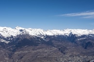A panoramic view of the Andes mountains with a clear sky and winding roads.