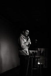 a man standing in a dark room holding a microphone