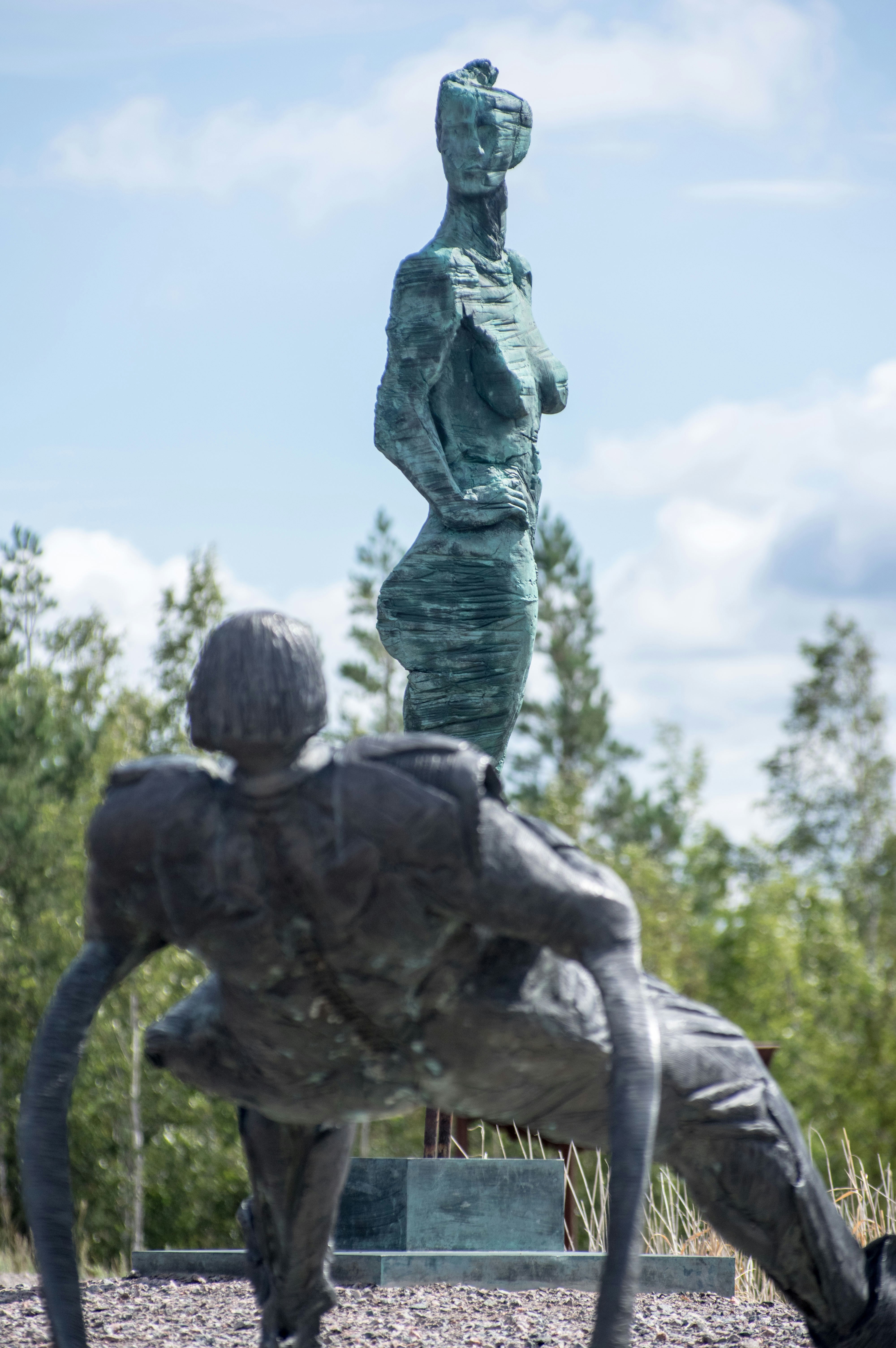 a statue of a woman standing next to a man