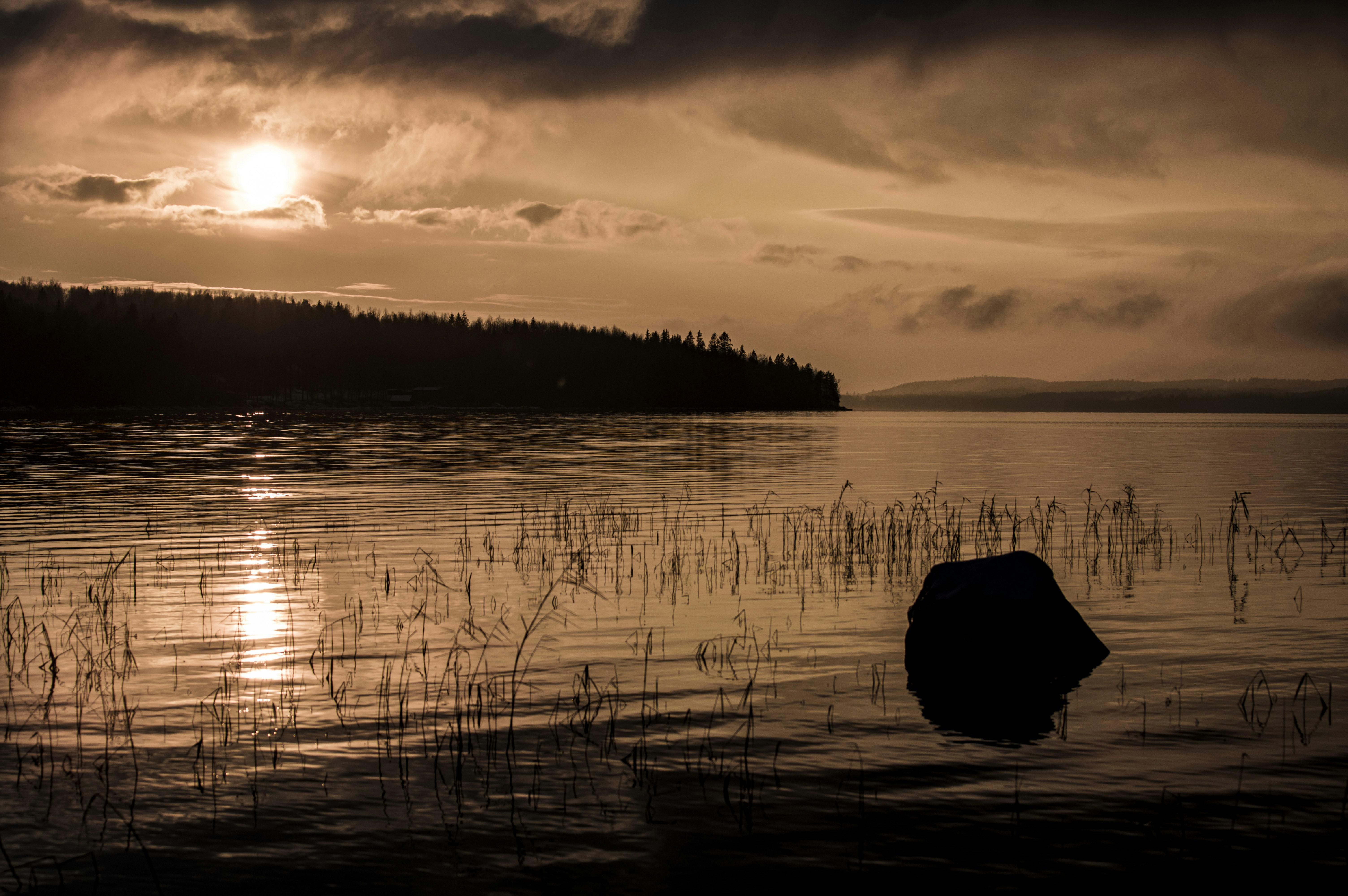 a body of water with a large rock in the middle of it