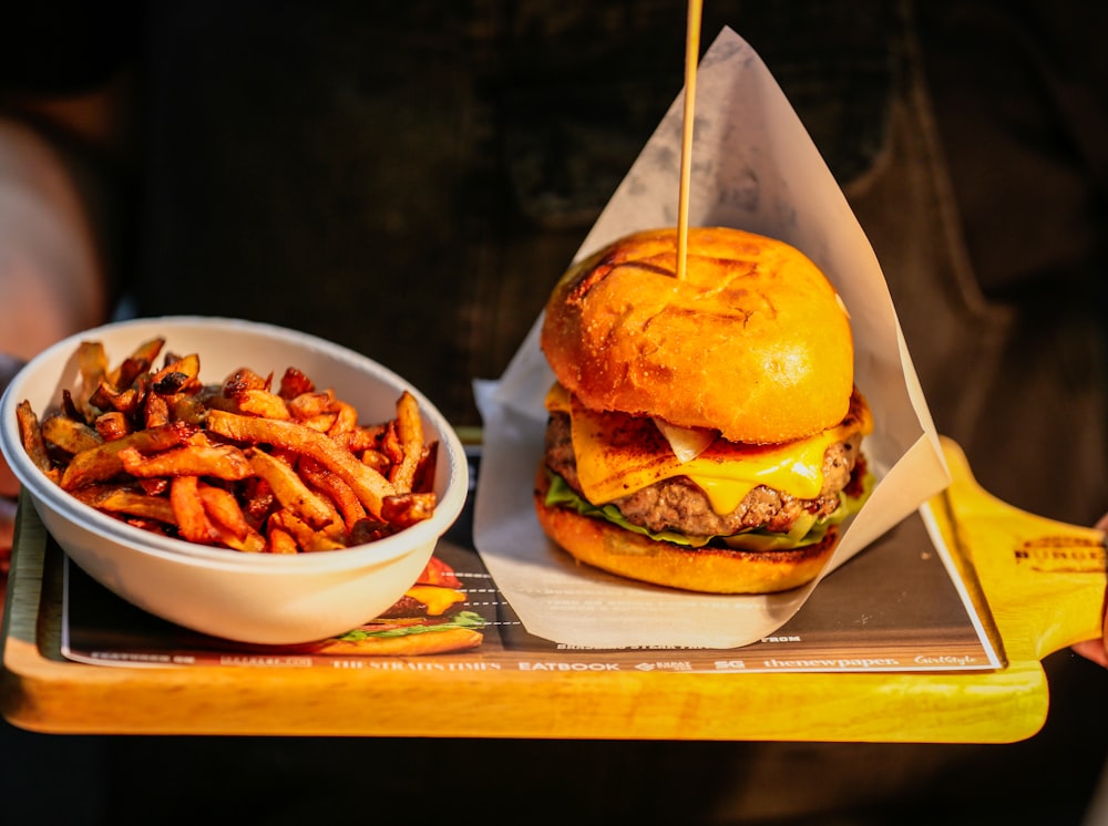 a tray with a burger and a bowl of fries