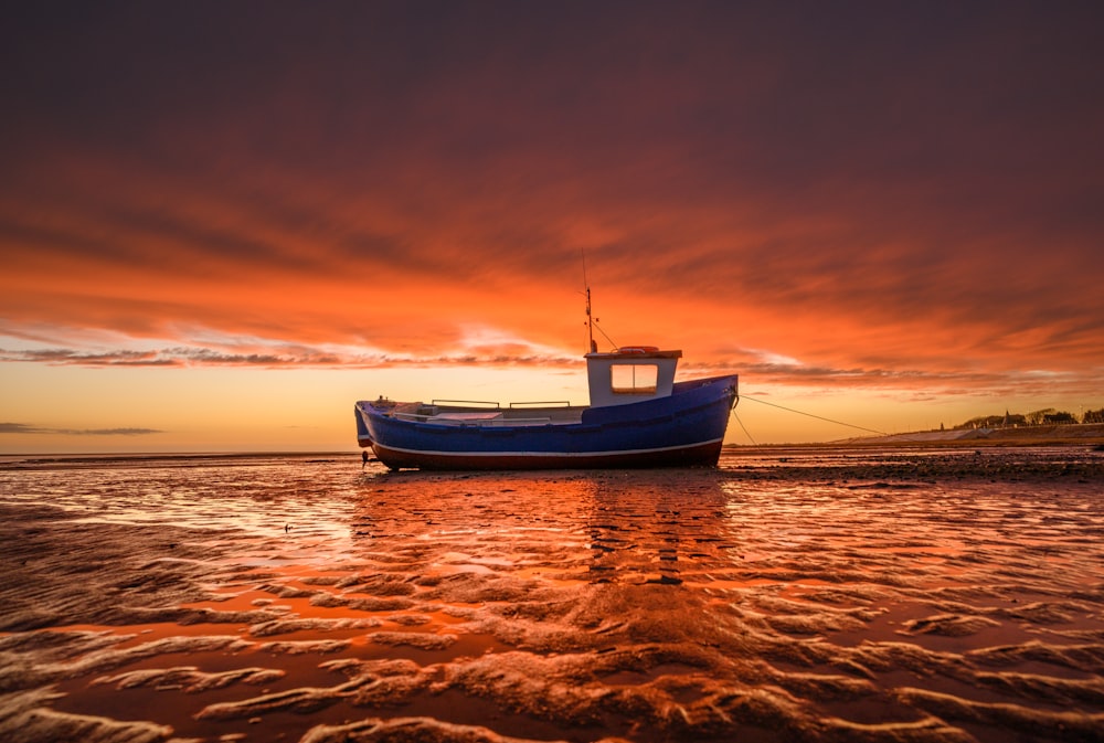 um barco sentado no topo de uma praia de areia