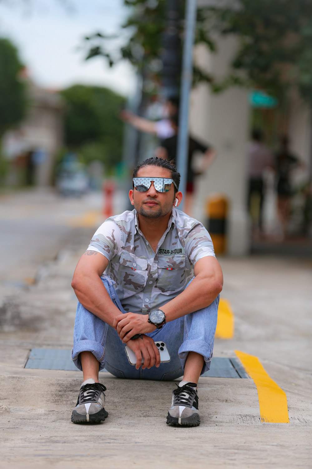 a man sitting on the ground wearing sunglasses