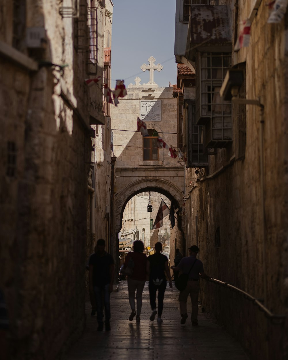 a group of people walking down a narrow alley way