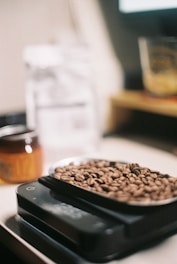 Close-up of raw spices and grains being measured on a scale in a production facility.