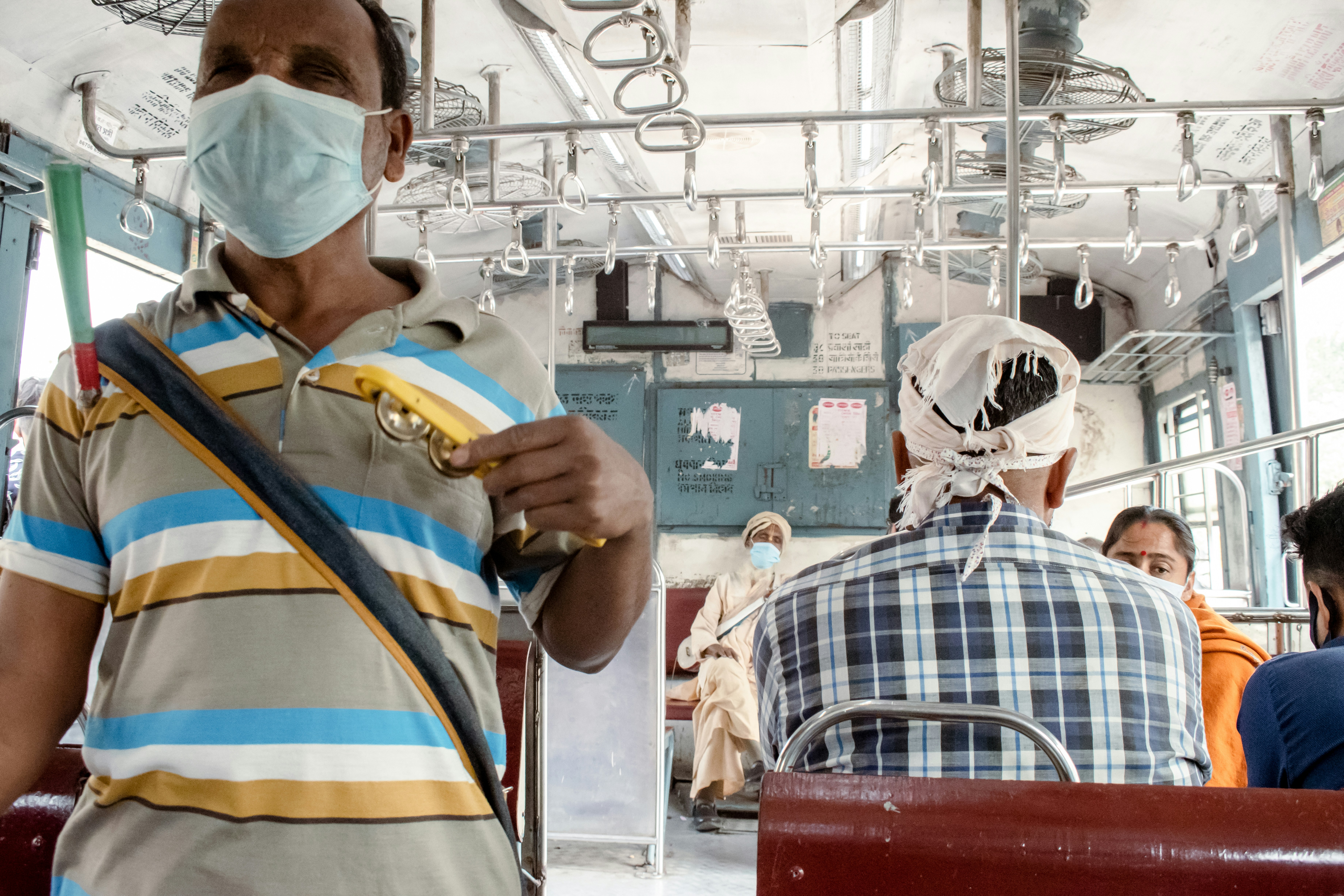 a man wearing a face mask while riding a bus