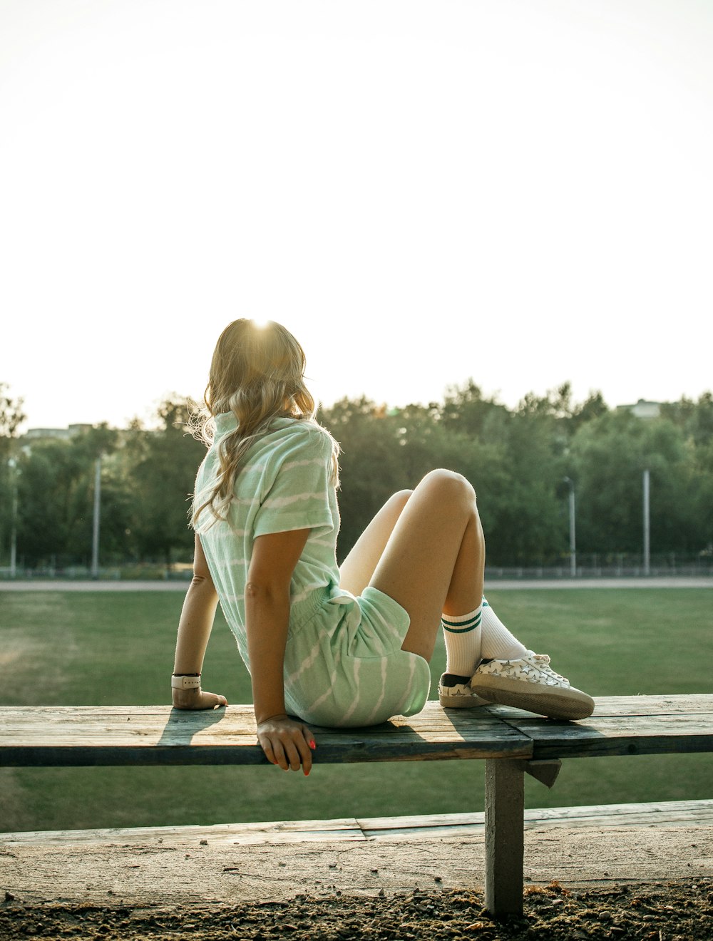 a woman sitting on a bench in a park