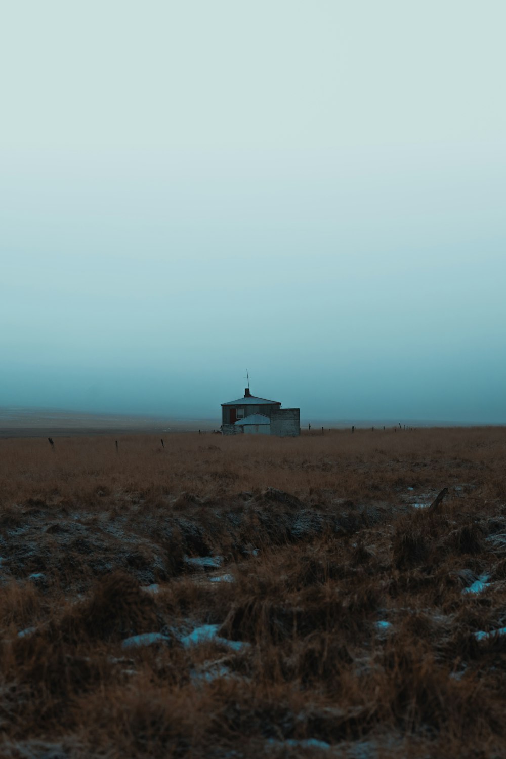 Une maison isolée dans un champ avec un fond de ciel