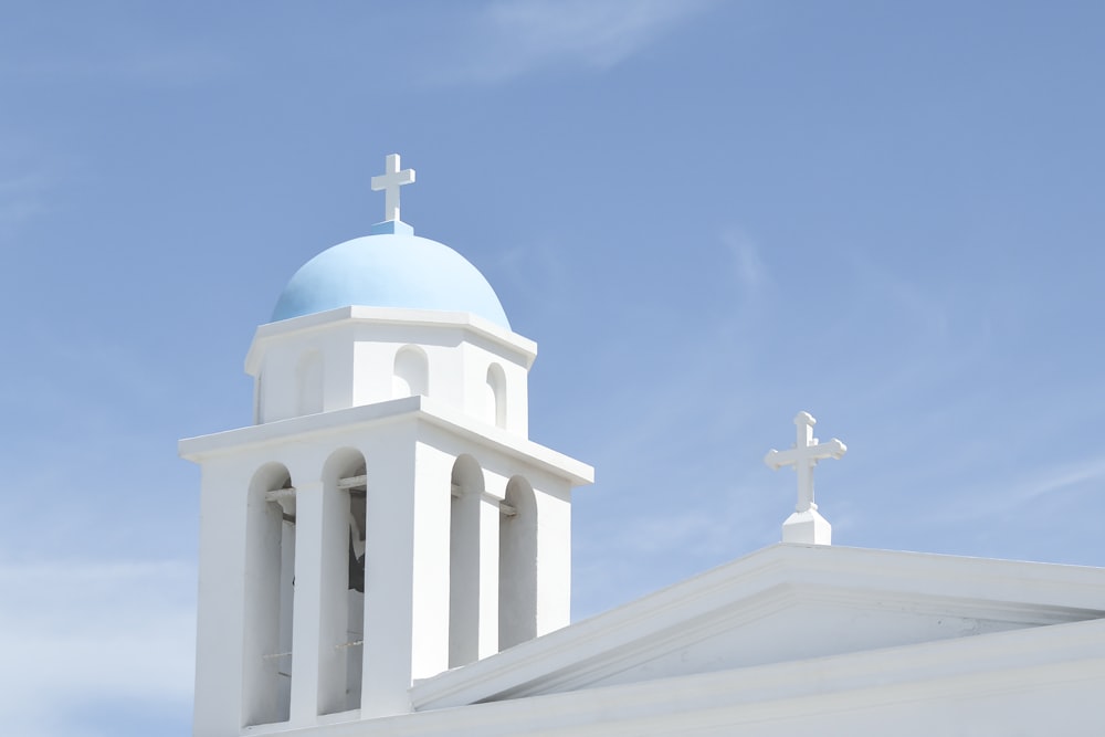 a white church with a blue dome and cross on top