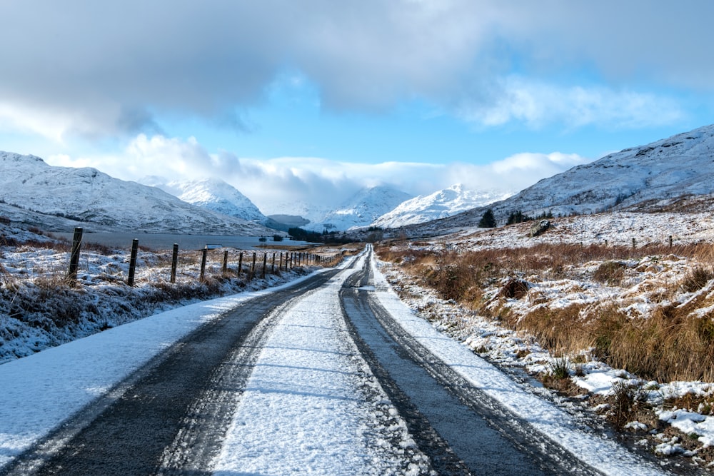 a road in the middle of a snowy field