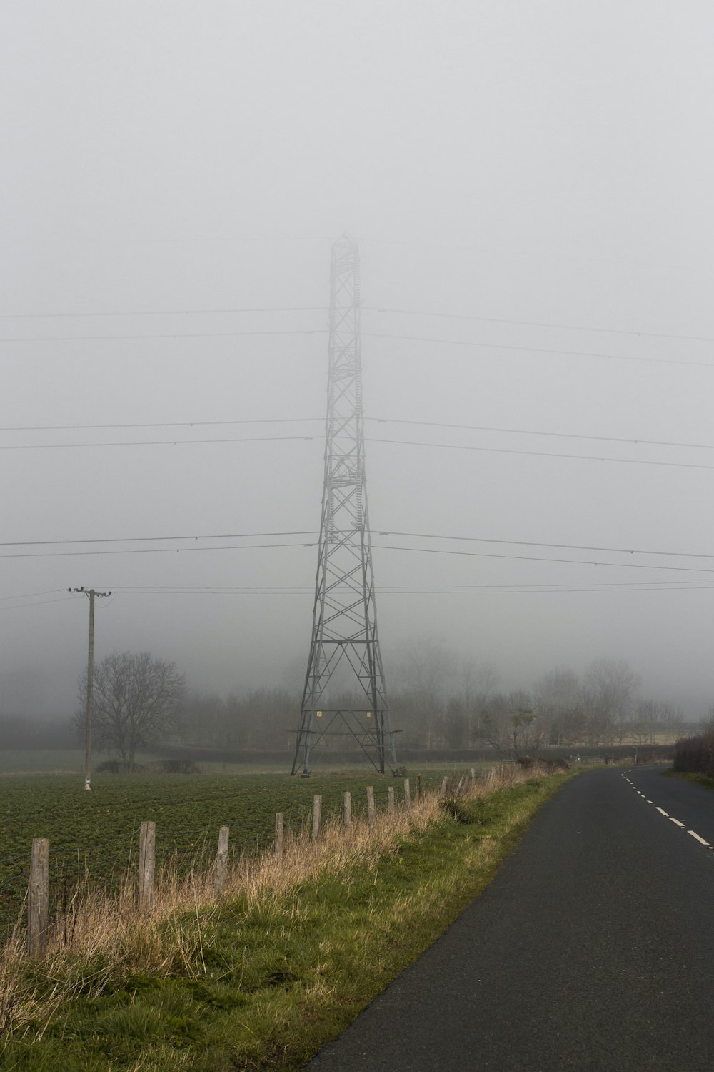 Une route brumeuse avec des lignes électriques au loin