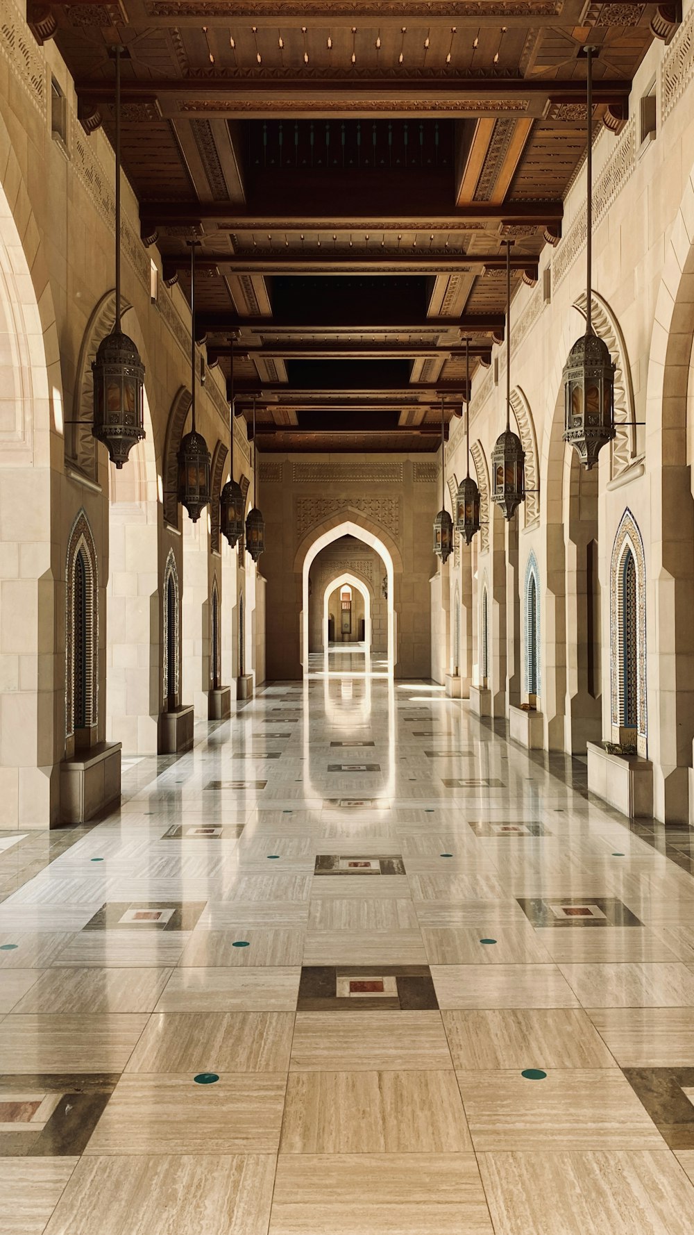a long hallway with a tiled floor and arches