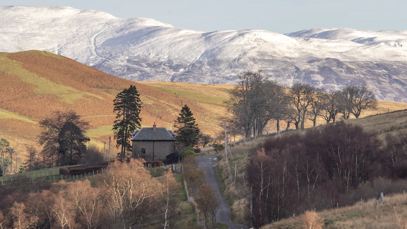 Cottage on a hill with mountains behind