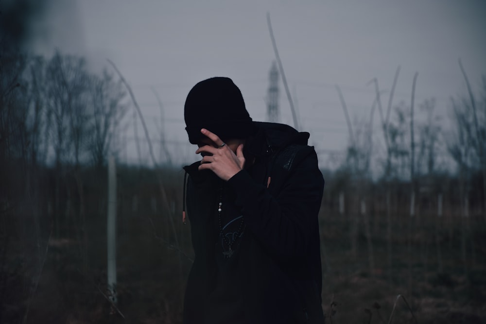 a person in a hooded jacket standing in a field