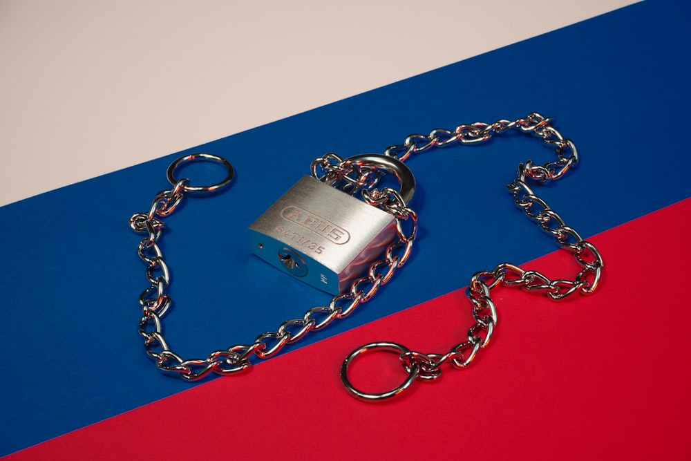 a lock and chain on a red, blue, and red background