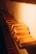 A row of neatly arranged gold bars on a shelf, illuminated by warm lighting, creating a luxurious and rich ambiance.