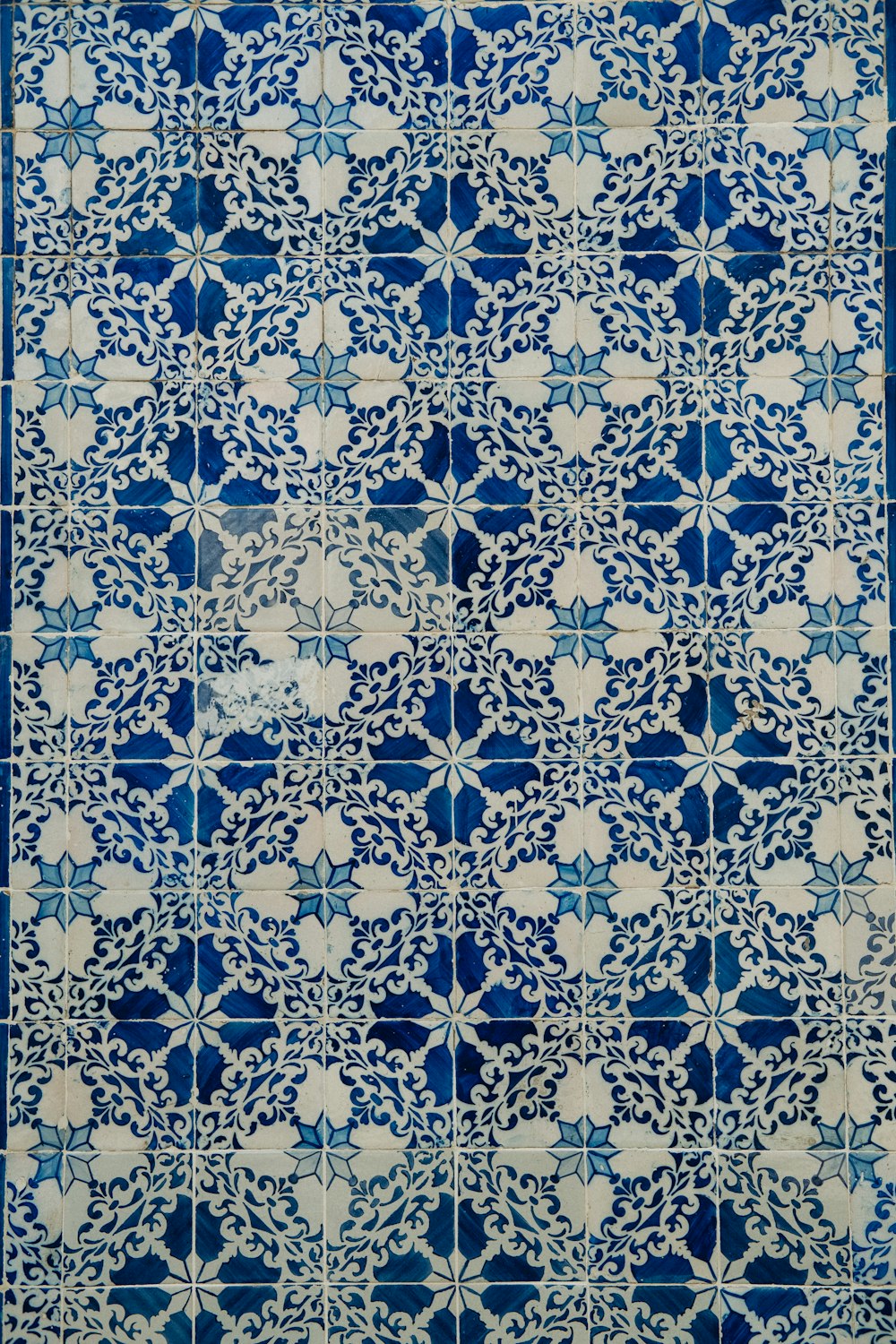 a blue and white tile with a design on it