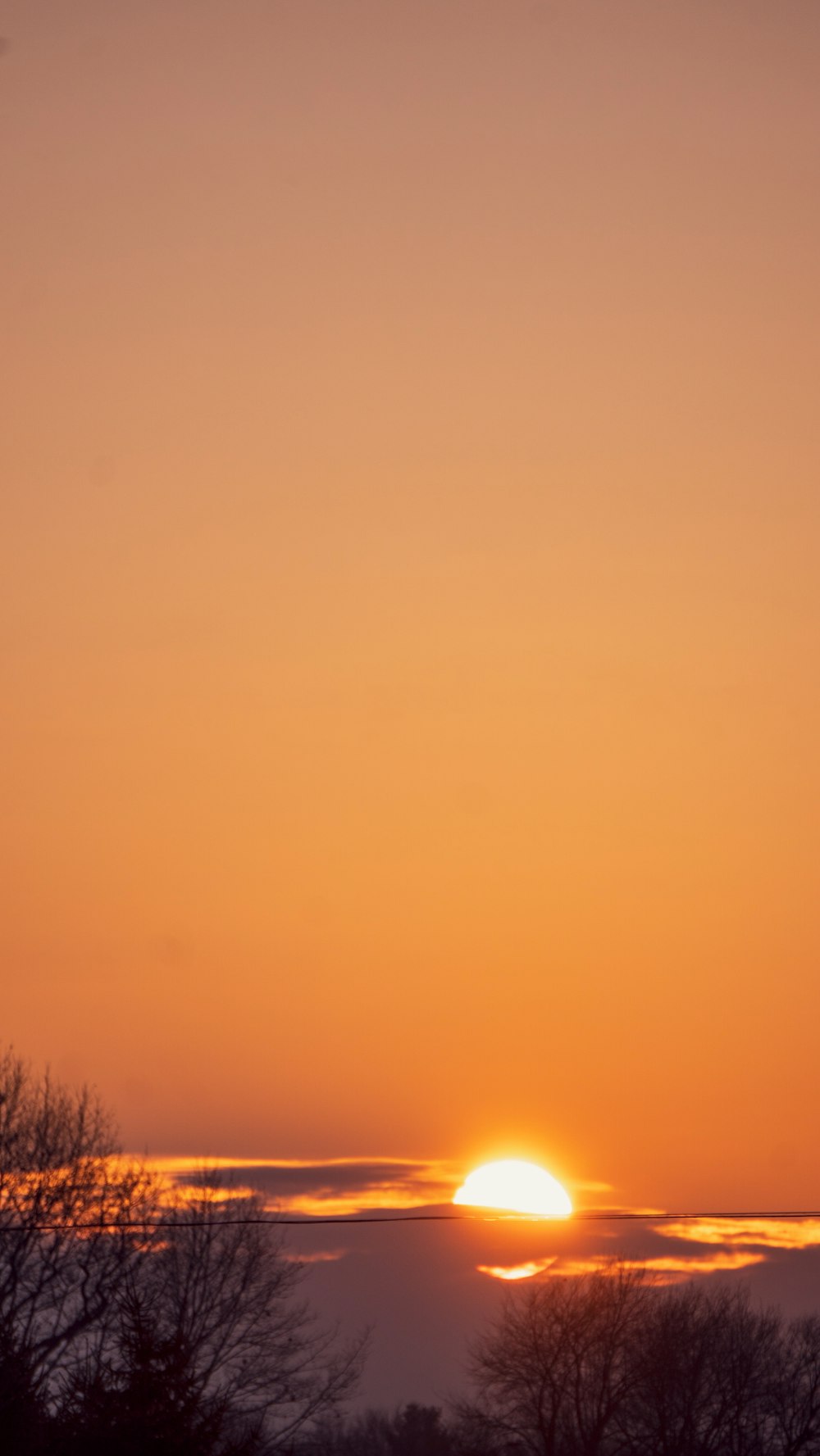 a plane flying in the sky at sunset