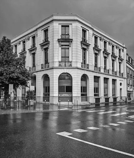 a black and white photo of a building on a rainy day