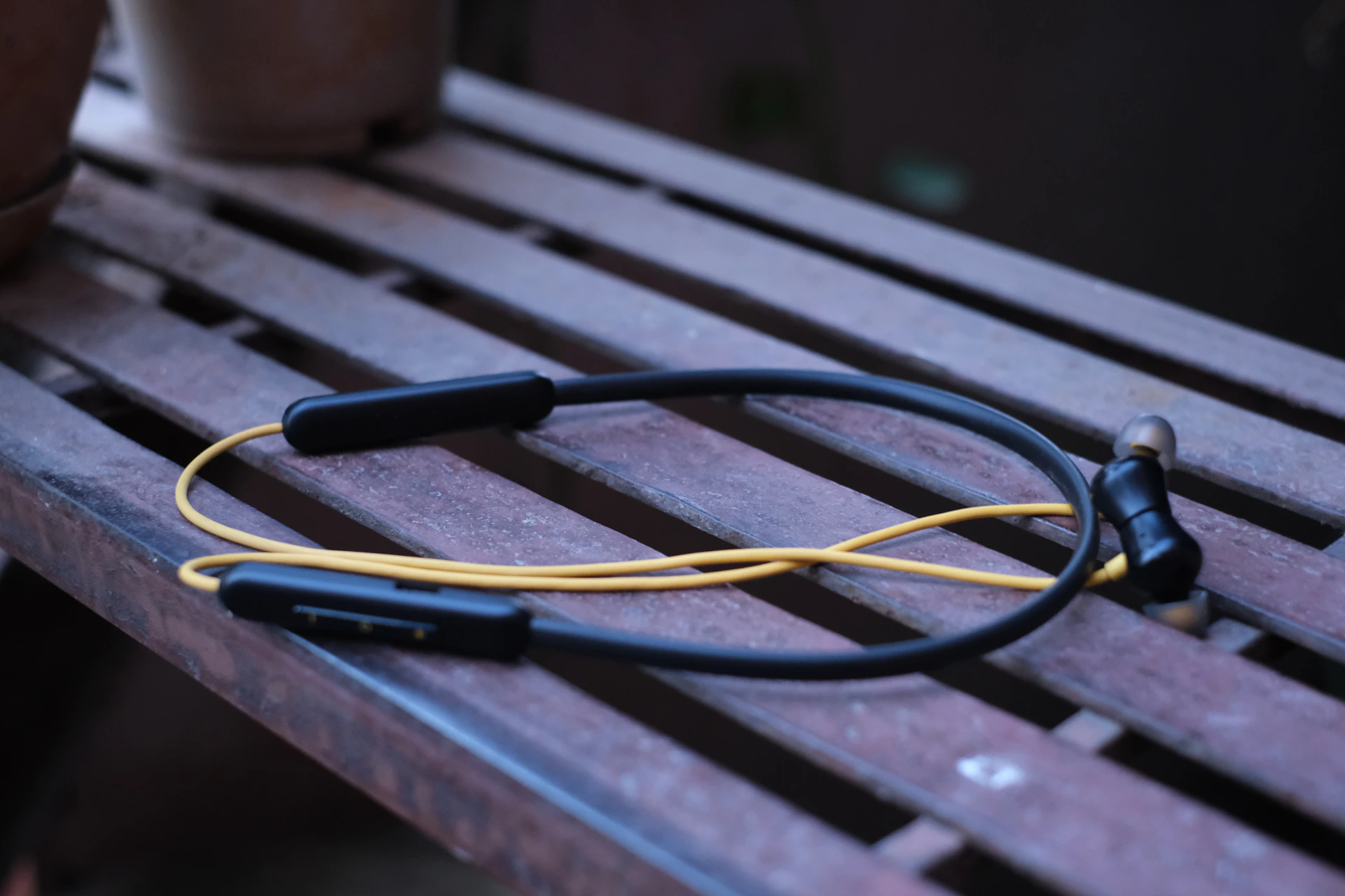 a pair of headphones sitting on top of a wooden bench