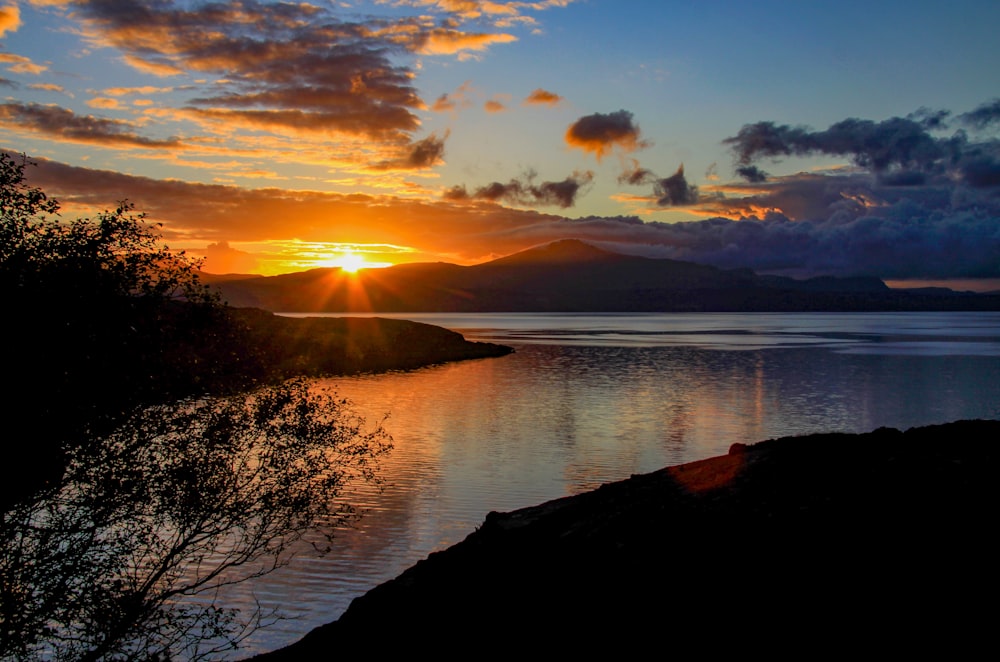 the sun is setting over a body of water