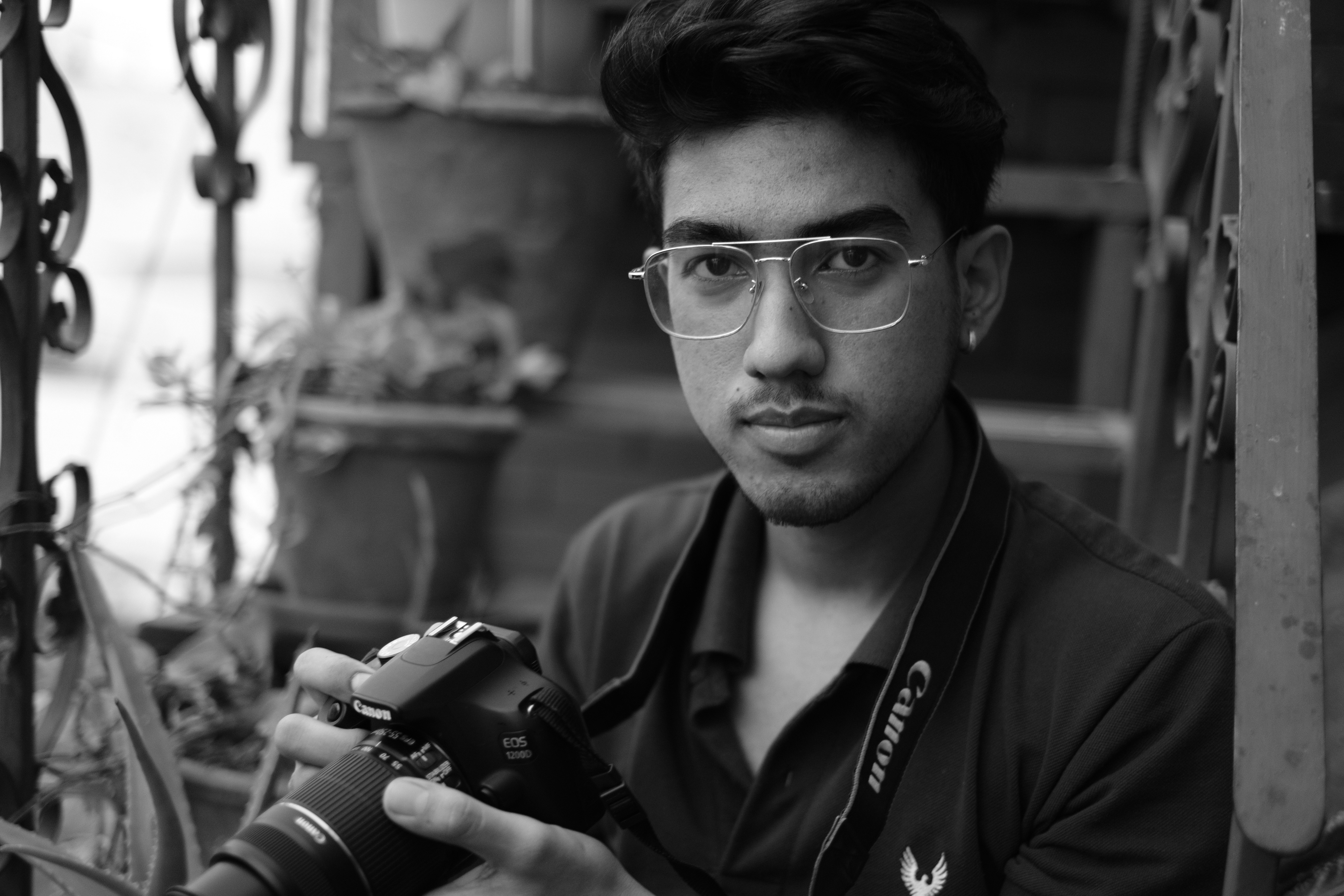 a man with glasses holding a camera in his hand