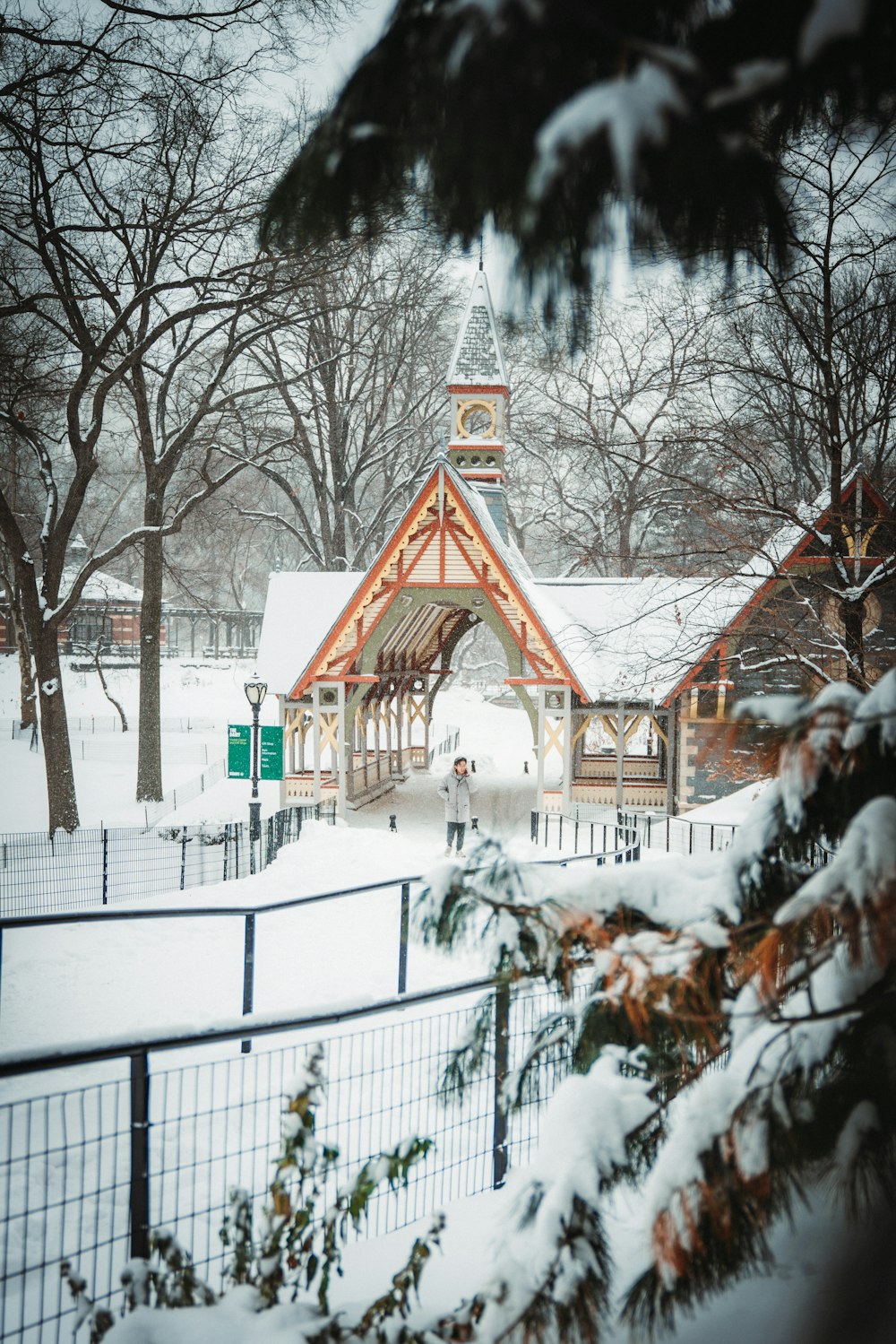 a building with a clock tower in the middle of a snowy field