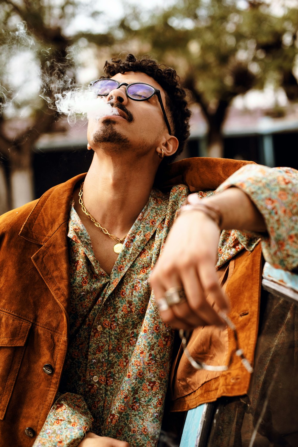 a man smoking a cigarette while sitting on a bench