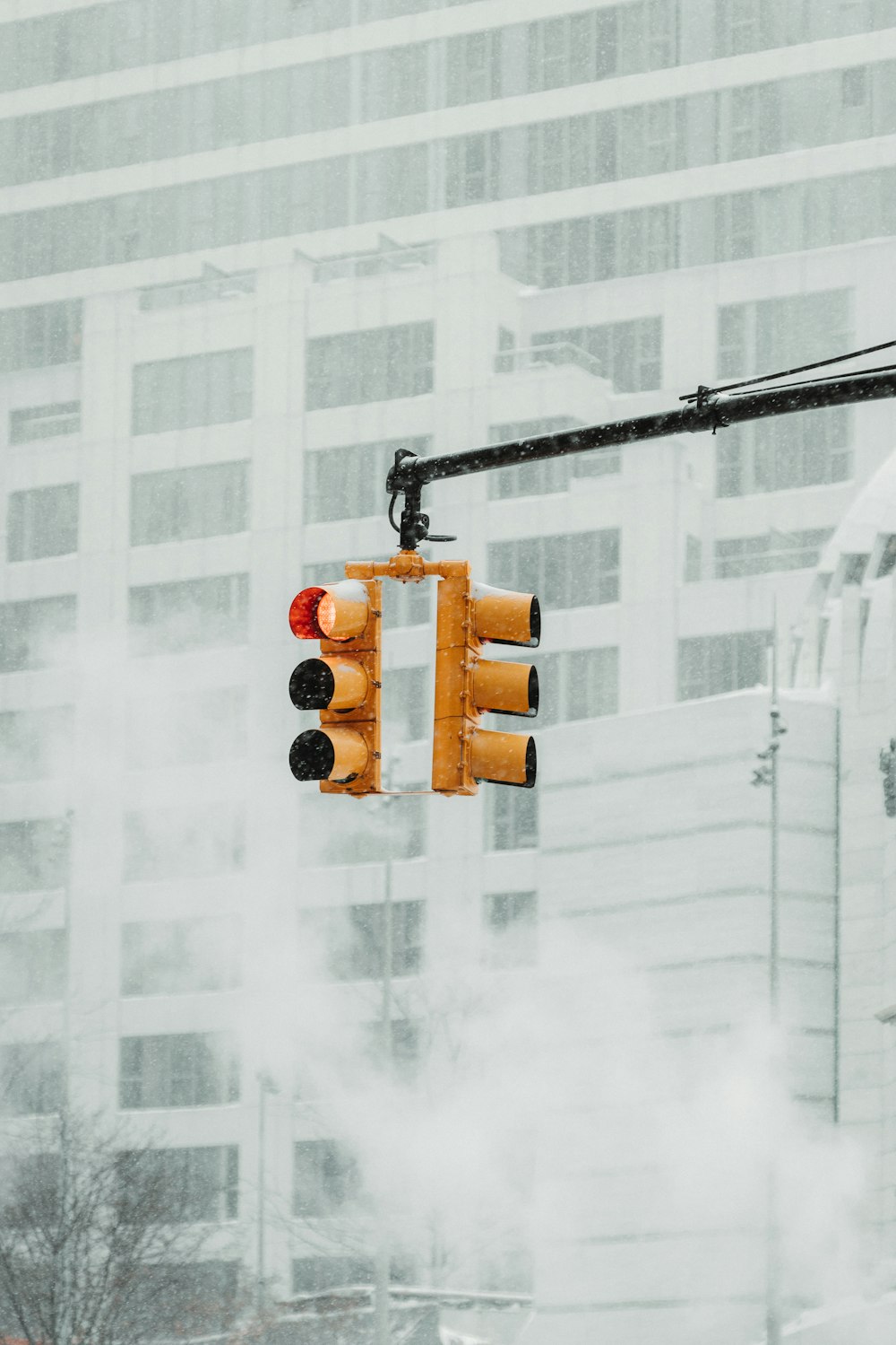 a traffic light hanging over a street next to a tall building