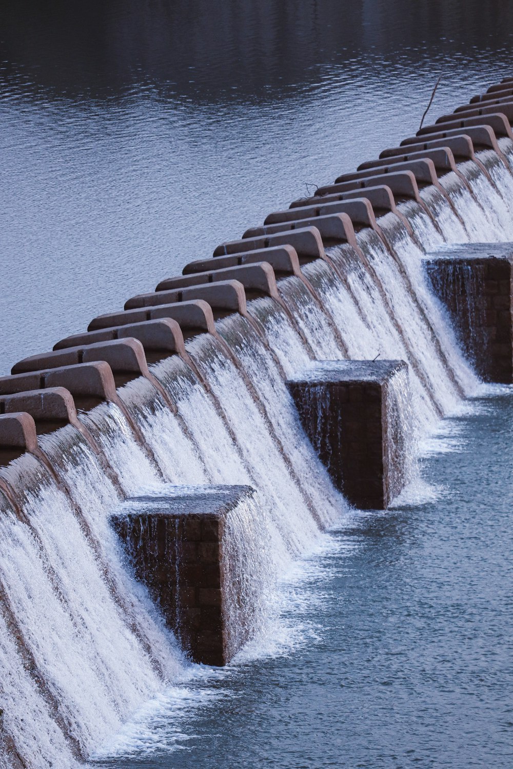 a row of water gushing out of a dam
