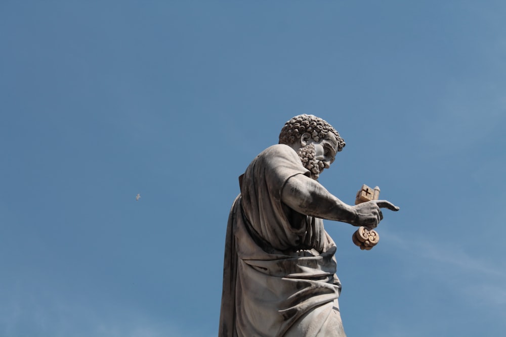 uma estátua de um homem com um pássaro em sua mão