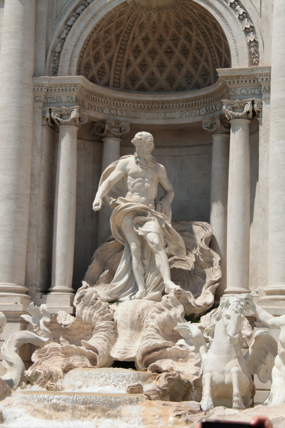 a statue of a man sitting on top of a fountain