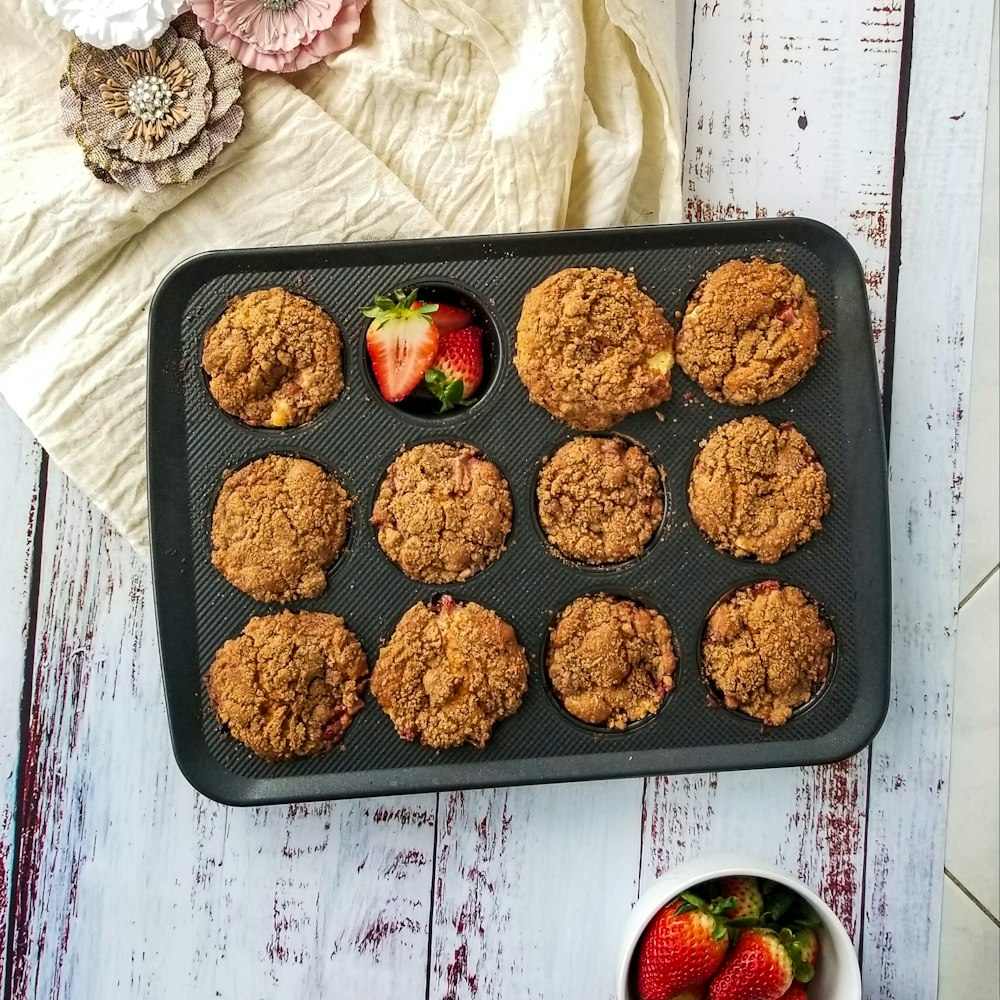 a muffin tin with muffins and strawberries in it